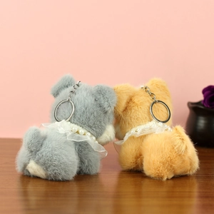 Détail de porte-clés chiots en peluche avec colliers de perles sur fond de bois