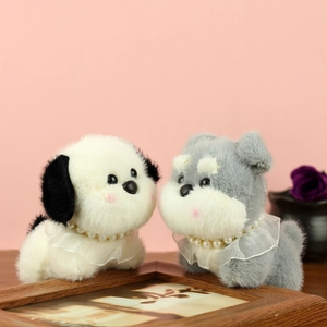 Détail de chiots schnauzer en peluche avec colliers de perles et dentelle douce