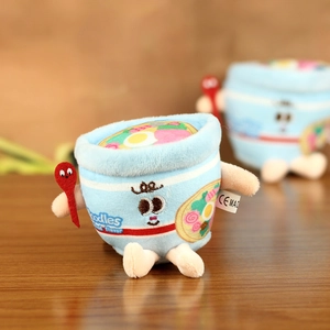 Close-up of cute plush blue cup noodle doll with CE certified label and red spoon