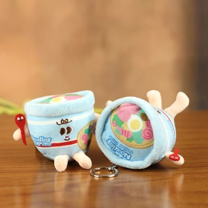 Cute blue seafood cup noodles plush keychain with cartoon embroidery on wooden surface