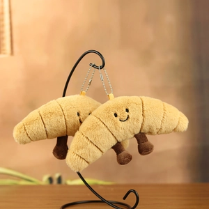 Detailed view of plush croissant keychains with cute smiles on a metal display stand