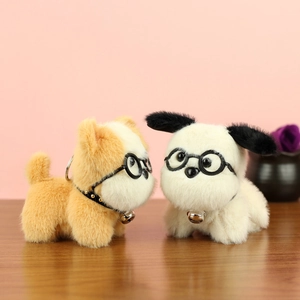 Détail de porte-clés chiens en peluche mignons avec lunettes et cloches sur bois