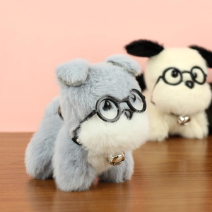 Gros plan de porte-clés chiots en peluche avec lunettes et colliers à clochettes