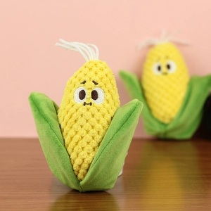 Close-up of plush corn pendant with cute facial expression and soft green leaves