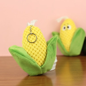 Close-up of a cute yellow plush corn keychain with soft green leaves and a metal ring