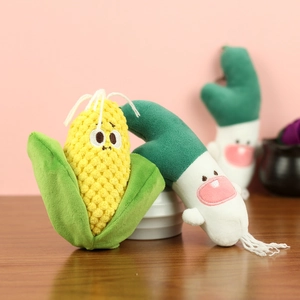 Close-up of cute plush vegetable pendants showing soft corn and green onion textures