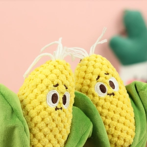 Close-up of cute plush corn pendant with detailed embroidery and soft yellow corn kernels