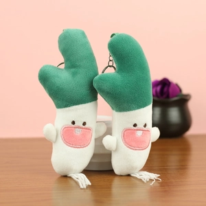 Close-up of cute plush green onion pendants with embroidered faces and silver keyrings
