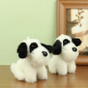 Cute spotted plush puppy keychains with long soft fur on a warm wooden background