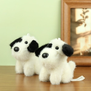 Detailed view of two plush dalmatian puppy keychains with soft black and white fur