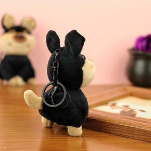Détail d'un joli porte-clés chien en peluche avec un mousqueton en métal noir robuste