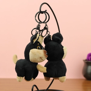 Détails macro de pendentifs chien-abeille en peluche avec fermoirs sur fond rose