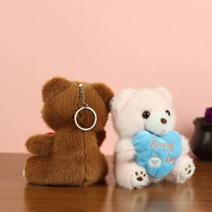 Detail of plush bear keychains with embroidered blue heart and silver metal ring