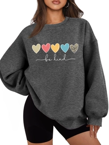 Détail de cinq cœurs colorés et imprimé 'be kind' sur tissu de sweat-shirt gris foncé