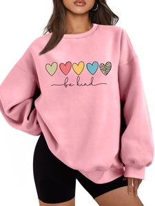 Détail du sweat rose avec cœurs colorés et texte be kind sur coton de haute qualité