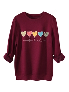 Détail d'un sweat bordeaux avec imprimés cœurs colorés et texte be kind cursif
