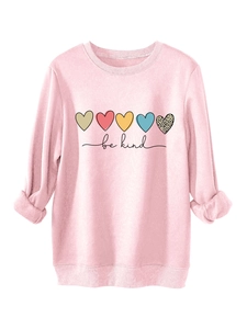 Détail du motif de cœur et texte be kind sur le sweat rose chaud à manches longues