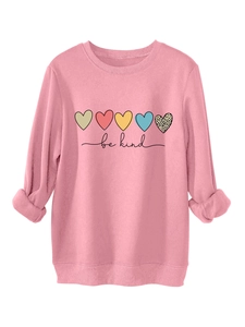 Détail du sweat rose avec des cœurs colorés et l'imprimé textuel be kind cursif
