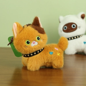 Detailed shot of an orange plush cat pendant with spiked collar and star embroidery