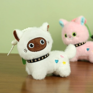 Detailed macro view of white plush cat keychain with embroidered details and collar