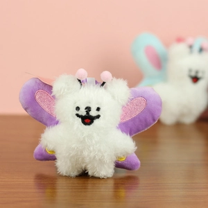 Close-up of RJ plush charm with soft white fur, purple butterfly wings and pink antennae