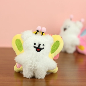 Detailed view of the soft white plush puppy keychain with yellow wings and pink antennas