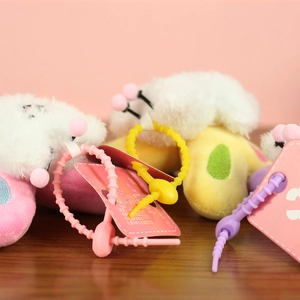 Detail of colorful plastic fasteners and soft plush puppy bee keychain charms