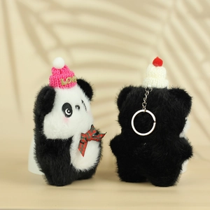 Close-up of plush panda keychain with pink LOVE hat and festive checkered bowtie