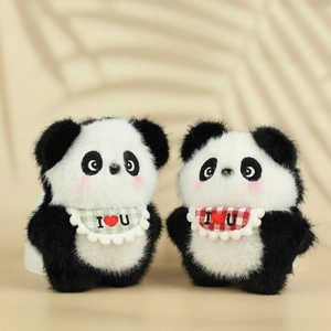 Close-up of plush panda keychains featuring red and green plaid bibs and soft fur detail