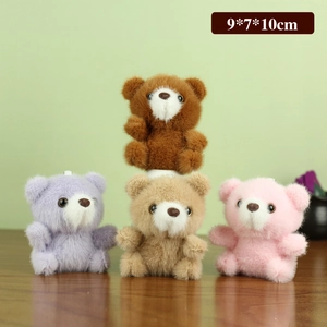 Porte-clés ours en peluche marron, violet, beige et rose sur une surface en bois