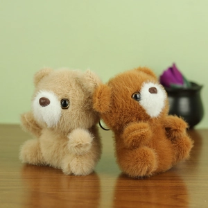 Lot de porte-clés ours en peluche beige et marron sur une surface en bois naturel