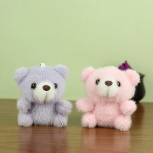 Détail de porte-clés ours en peluche rose et violet avec texture douce et boucles de suspension