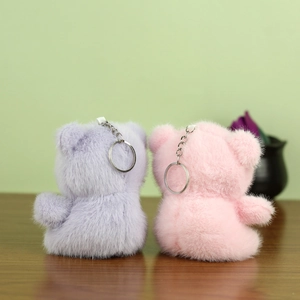Détail des porte-clés ours en peluche rose et violet avec fourrure synthétique et anneaux argentés
