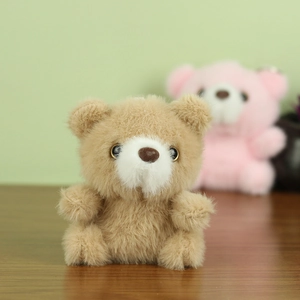 Gros plan d'un pendentif ours en peluche marron clair doux avec une texture moelleuse