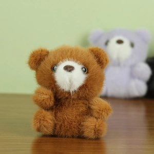 Gros plan d'un porte-clés ours en peluche marron doux avec une texture duveteuse