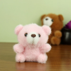 Gros plan d'un pendentif ours en peluche rose avec texture douce et visage mignon