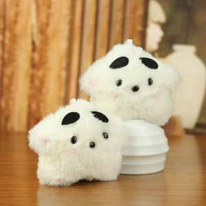 Cute star-shaped plush toy keychains with soft white fur and adorable faces on a wooden table
