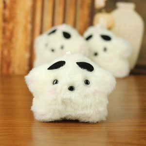 Close-up of soft cream plush star keychain with pink cheeks on warm wooden surface