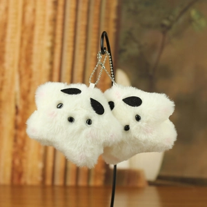 Detail view of two plush star-shaped keychains with soft faux fur and pink blush accents