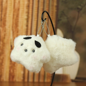 Detail of plush star keychains with soft cream fur, black ears and pink blush details