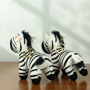 Nahaufnahme von Zebra-Plüschanhängern mit schwarz-weißen Streifen und goldenem Karabiner