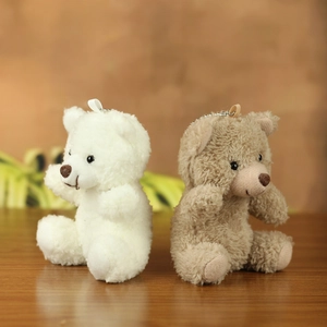 Detail of cute white and brown plush teddy bear keychains with metal beaded chains