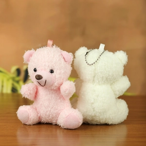 Close-up of pink and cream teddy bear plush keychains with metallic bead chains