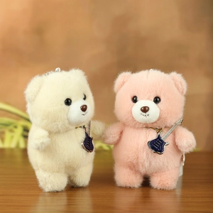 Detail of cute plush teddy bear pendants in cream and pink with guitar charms