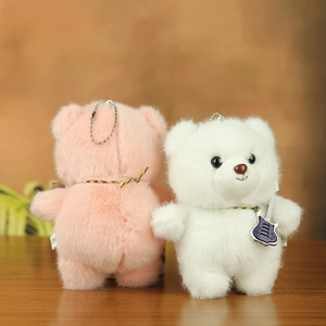 Detail of plush teddy bear keychains in pink and white with a purple guitar charm