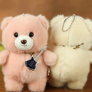 Detail of plush teddy bear pendants in pink and beige with soft fluffy texture and chain