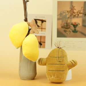 Detail von Plüsch-Ingwer und Mango-Anhängern mit goldenen Ketten auf einem Ast