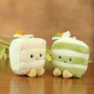 Cute plush cake slices with striped design and floral topper on a wooden surface
