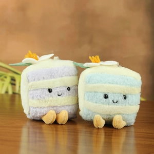 Close-up of cute plush cake slice charms in blue and purple with smiling faces