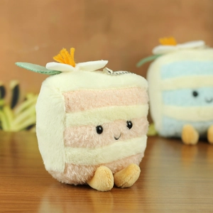 Close-up of plush triangle cake keychain with soft fabric and metal bead chain